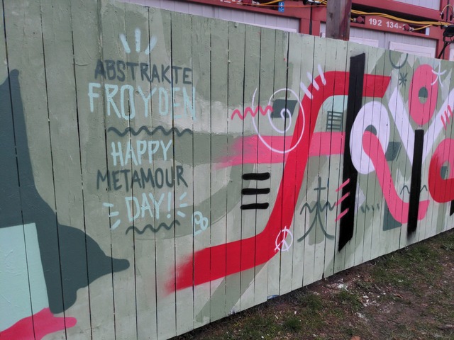Abstract letters painted on a wodden fence.